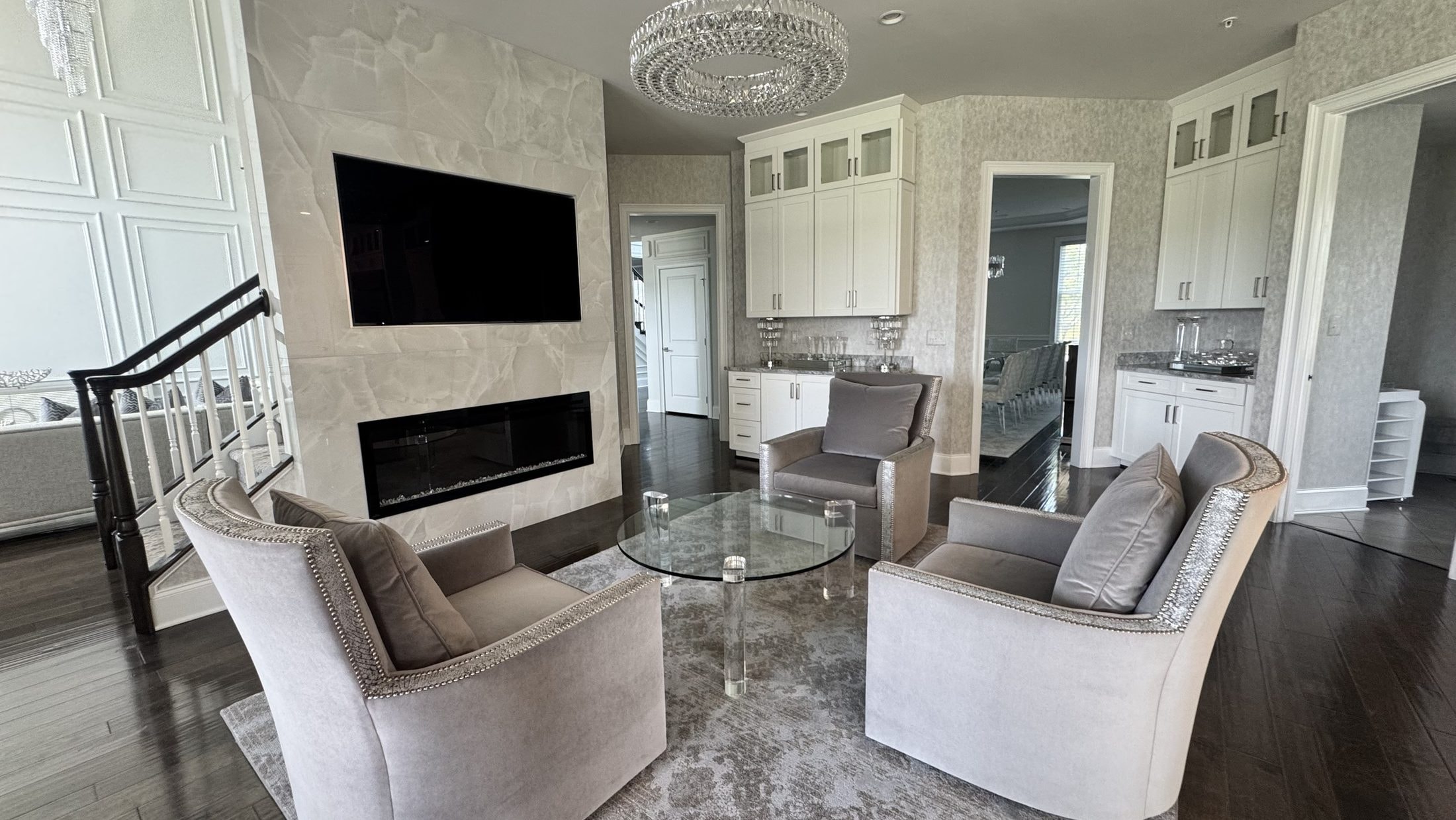 Fireside Sitting Room: onyx fireplace wall, swivel chairs, crystal ring chandelier, designed and furnished by John Hashempour